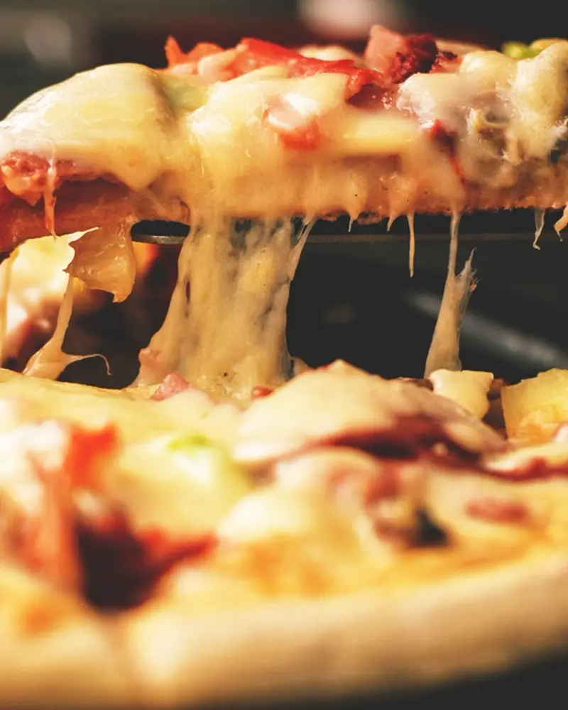 Porción de pizza con muzzarella estirándose